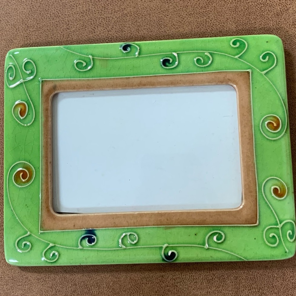 Green 3x5 picture frame with swirl design and blue and red spots.